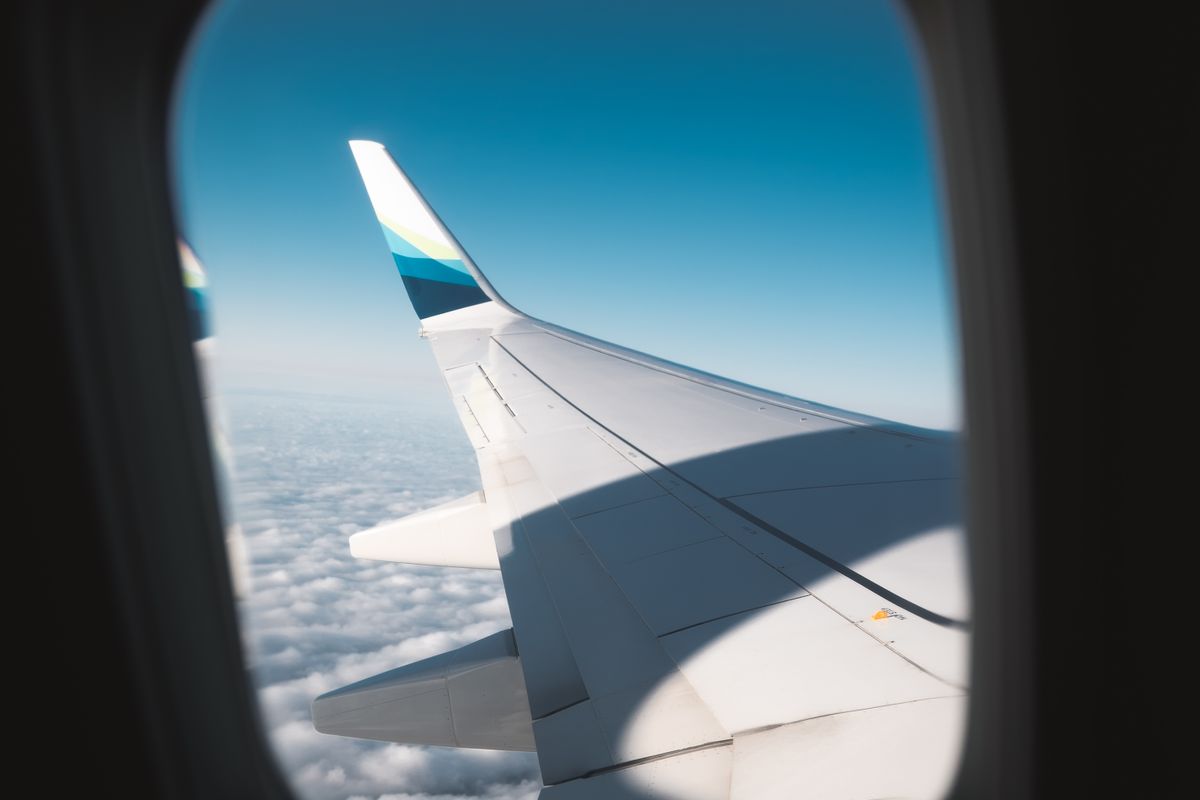 Troca de casa internacional: janela de avião sobre as nuvens